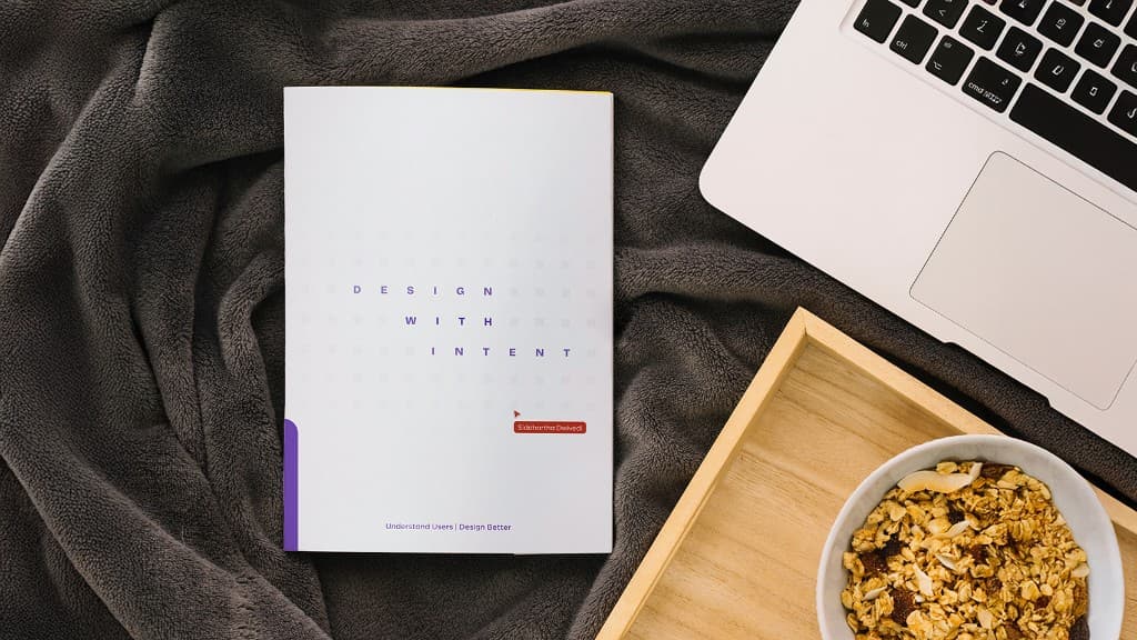 Design With Intent book by Siddhartha Dwivedi on a desk with laptop and breakfast bowl